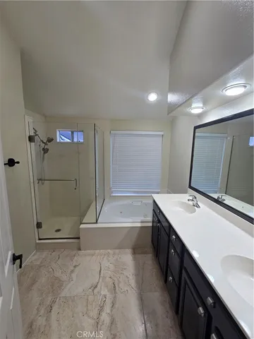 a bathroom with a sink a large mirror and a shower