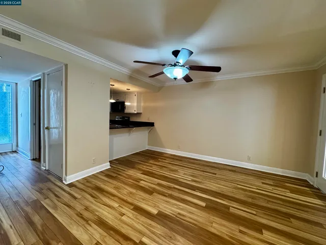 a view of an empty room with wooden floor