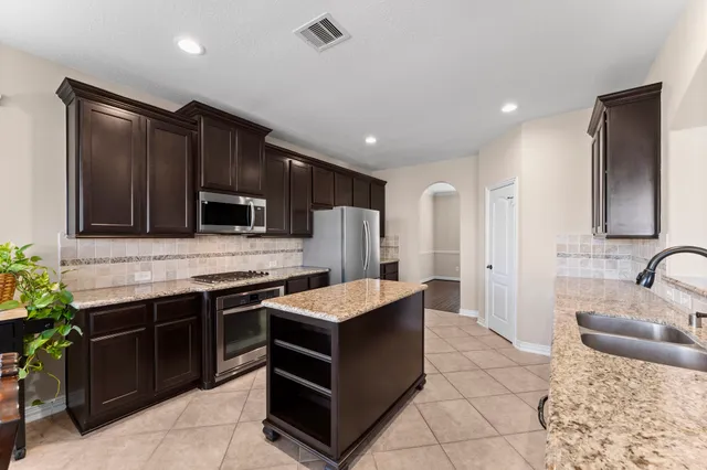 a kitchen with stainless steel appliances granite countertop a sink stove and refrigerator