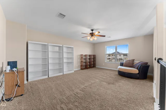 a view of a livingroom with furniture and a ceiling fan
