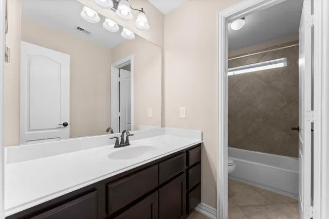 a bathroom with a sink a tub and a mirror
