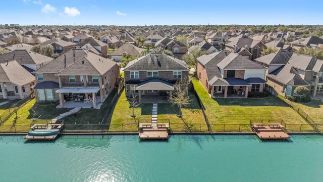 an aerial view of a house with a big yard and large trees