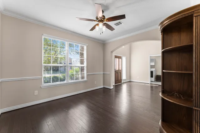 a view of an empty room with a window and wooden floor