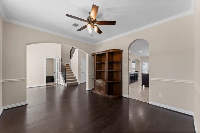 a view of empty room with wooden floor and ceiling fan