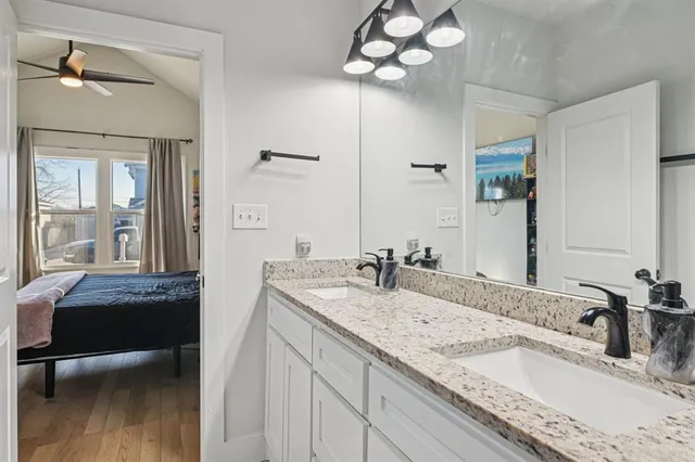 a bathroom with a granite countertop sink a mirror and shower
