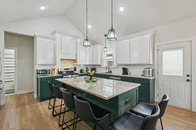 a kitchen with a table chairs stove and cabinets