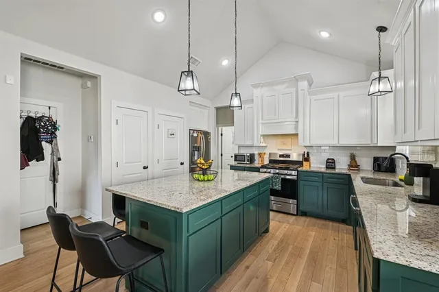 a kitchen with a sink refrigerator and cabinets