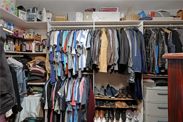 a view of walk in closet with clothes and shoes
