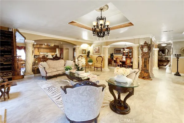 a living room with furniture a chandelier and a flat screen tv