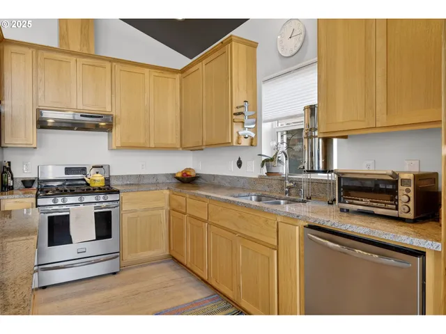 a kitchen with stainless steel appliances granite countertop a stove a sink and a microwave