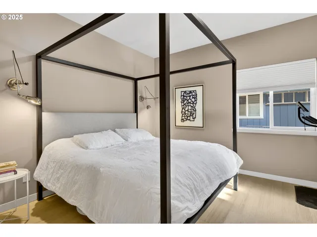 a bedroom with a bed and a painting on the wall