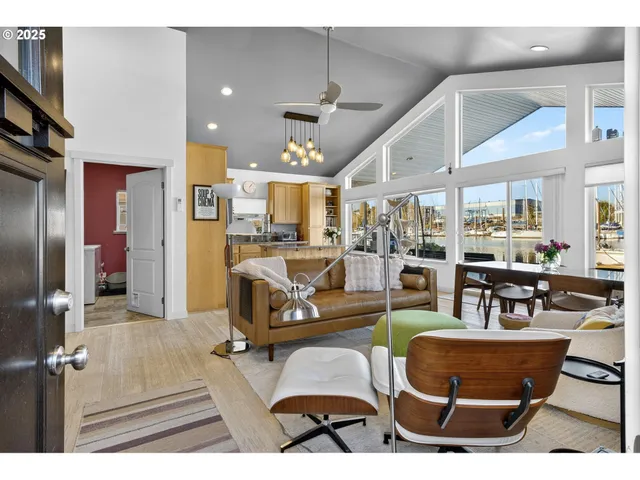 a living room with furniture kitchen view and a chandelier