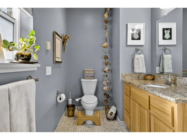 a bathroom with a granite countertop toilet sink and mirror