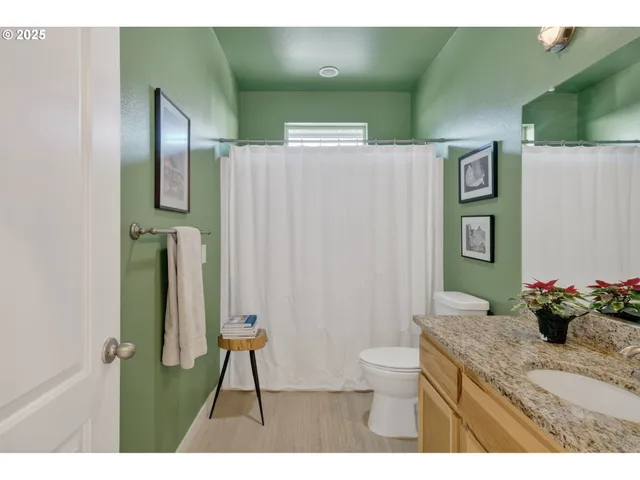 a bathroom with a granite countertop sink a toilet and a mirror