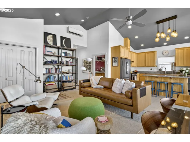 a living room with furniture kitchen view and a chandelier