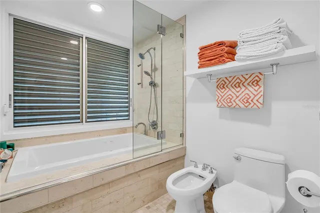 a bedroom with a bed a flat screen tv and a large window with the outer view