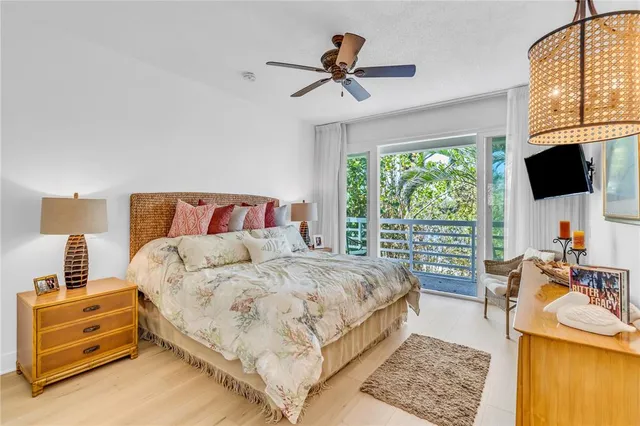 a bedroom with a bed a flat screen tv and balcony view