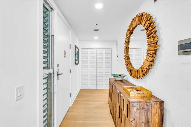 a view of a hallway with entryway wooden floor and front door