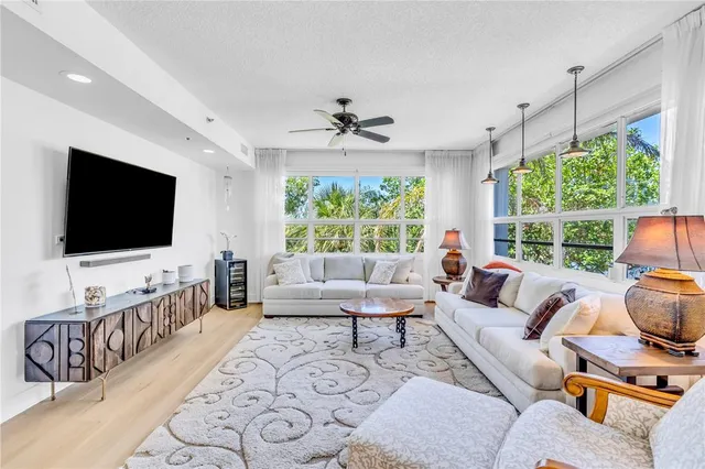 a living room with furniture a flat screen tv and a large window