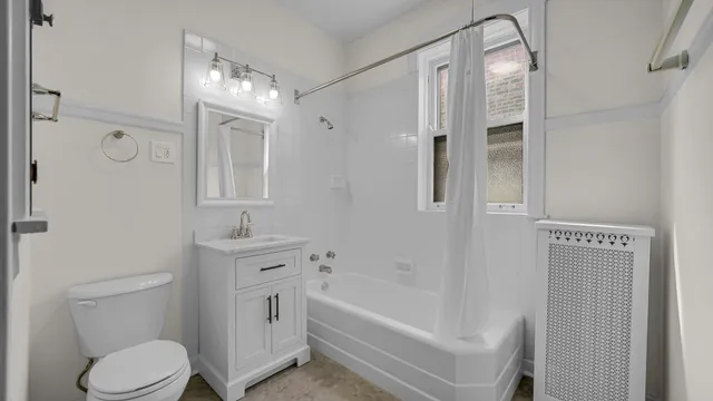 a bathroom with a bathtub shower sink vanity and toilet