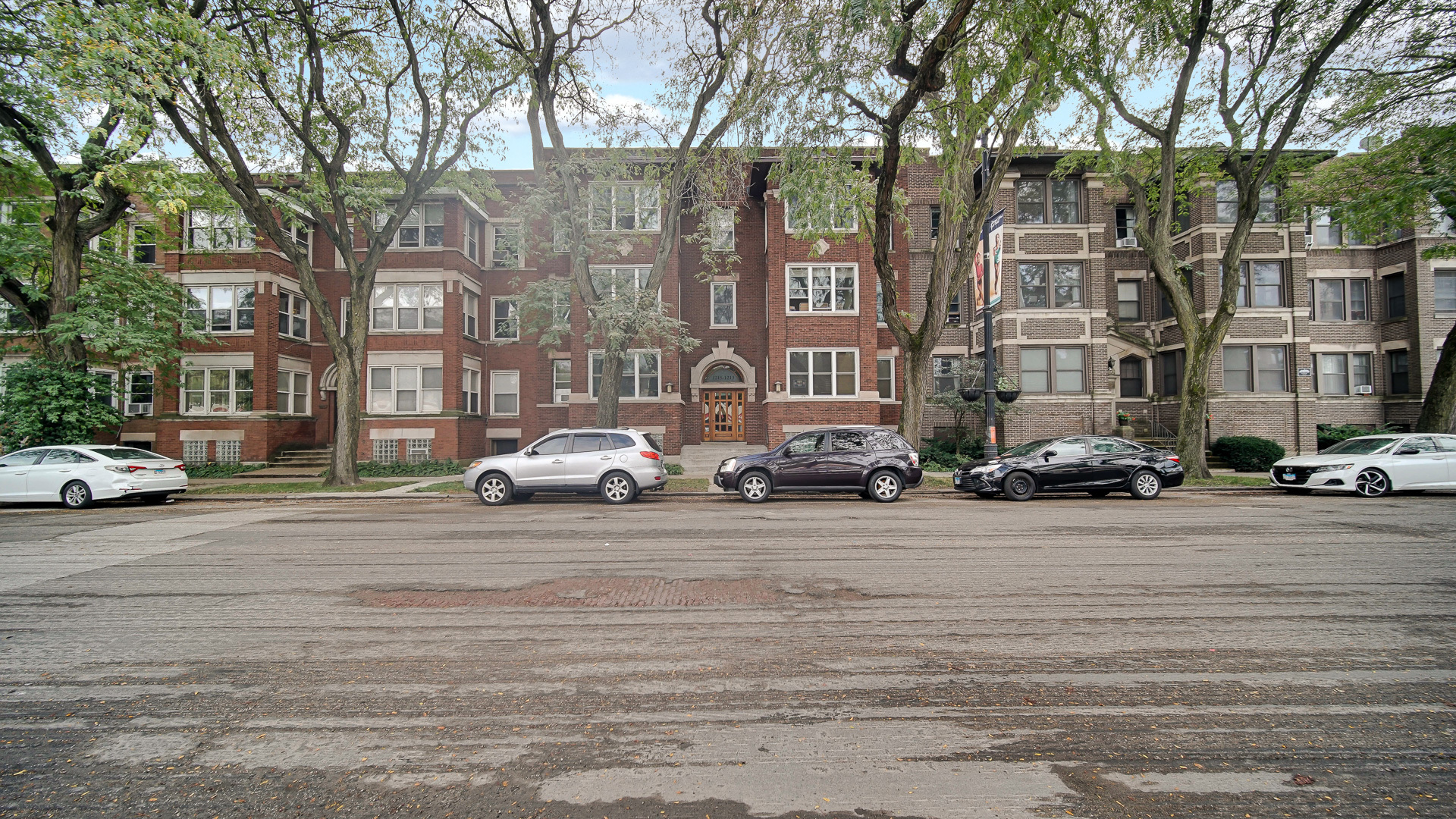 1213 East 53rd Street, Unit 3W Chicago, IL 60615 - Photo 21 of 21 a city street lined with buildings and cars