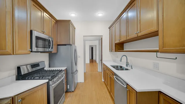 a kitchen with stainless steel appliances granite countertop a sink a stove and a refrigerator
