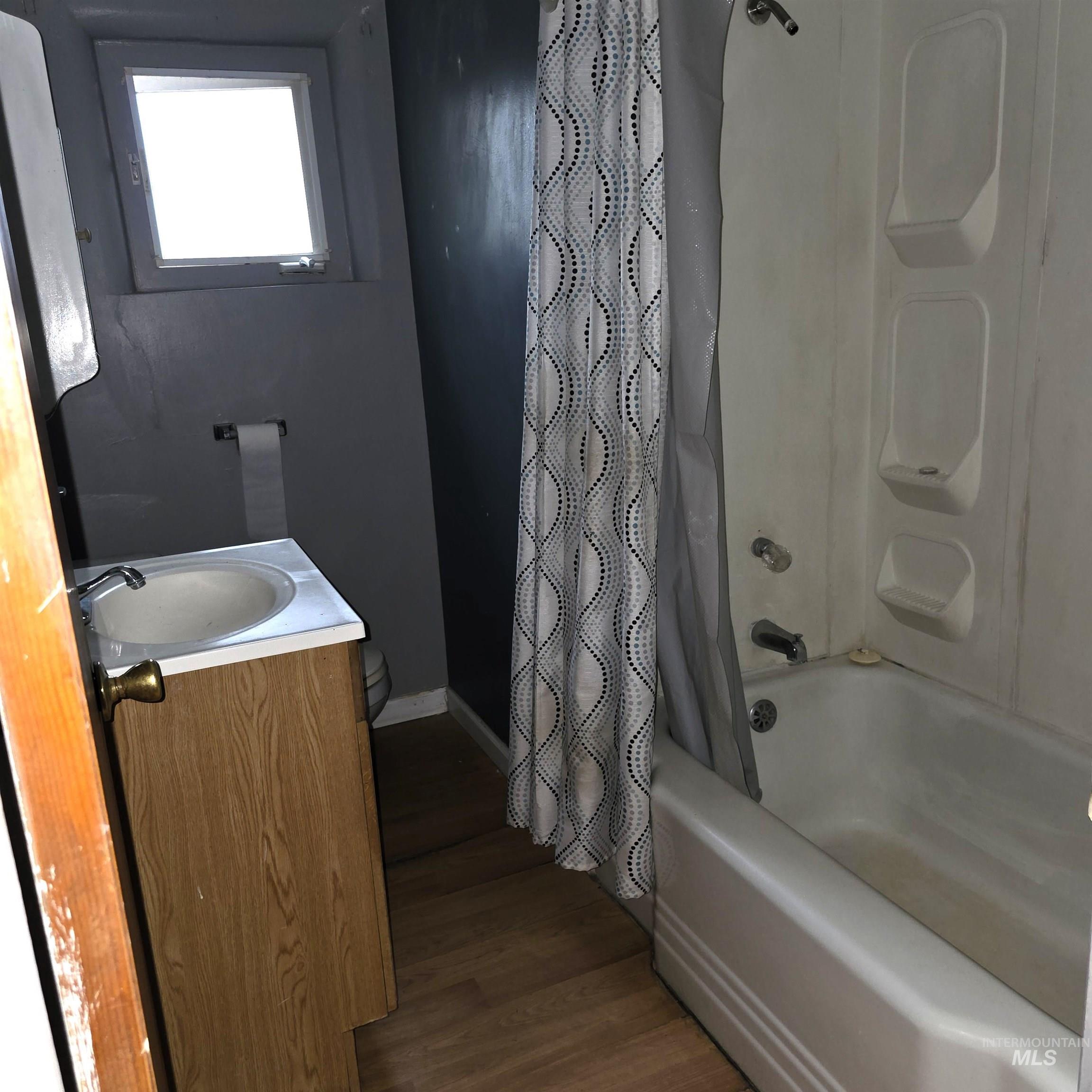 935 Preston Avenue Lewiston, ID 83501 - Photo 17 of 22 Full bath with vanity, dark wood-style floors, and shower / bath combination with curtain