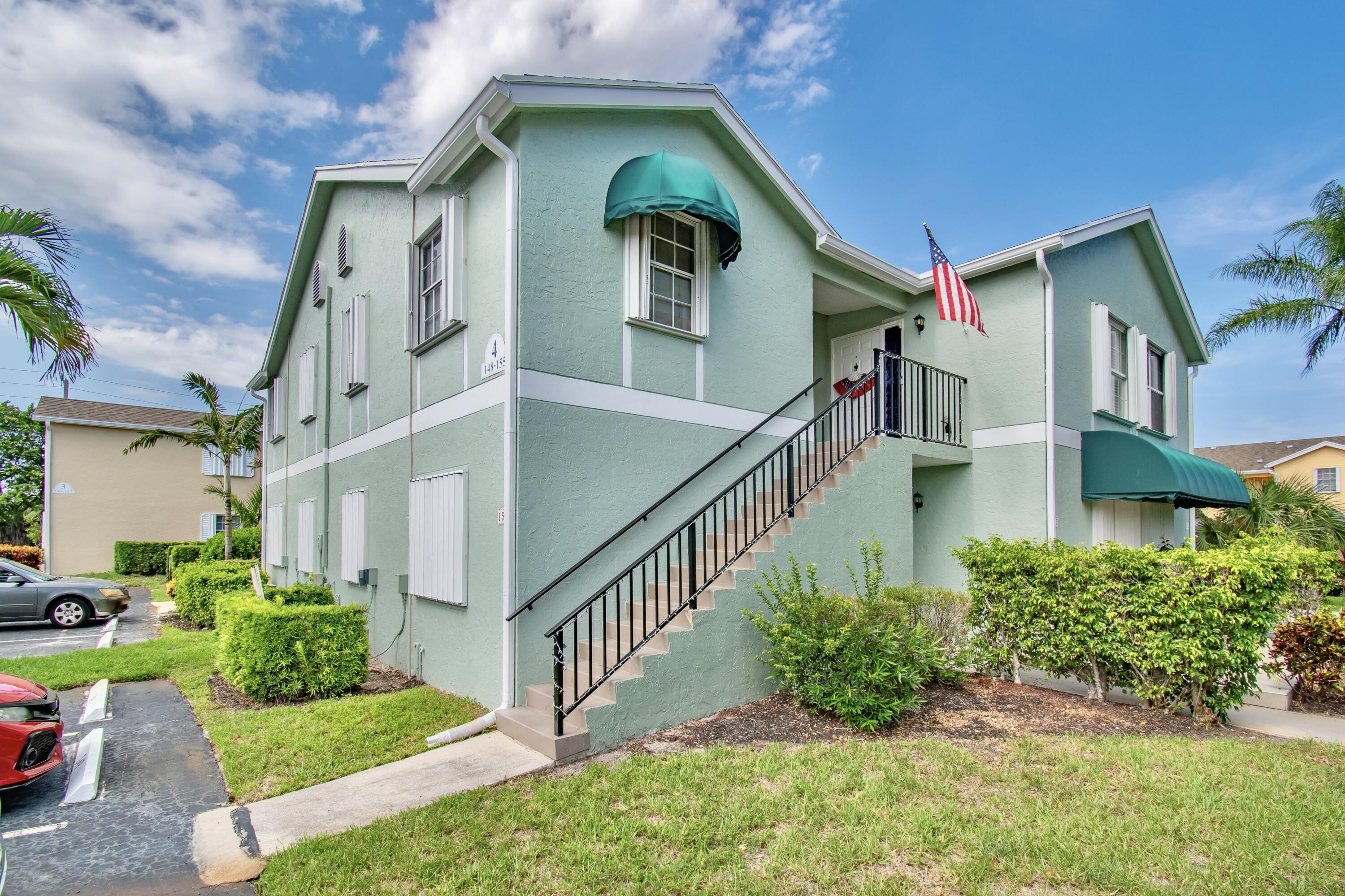151 Waterside Drive Hypoluxo, FL 33462 - Photo 2 of 30 a view of a house with brick walls and flower plants