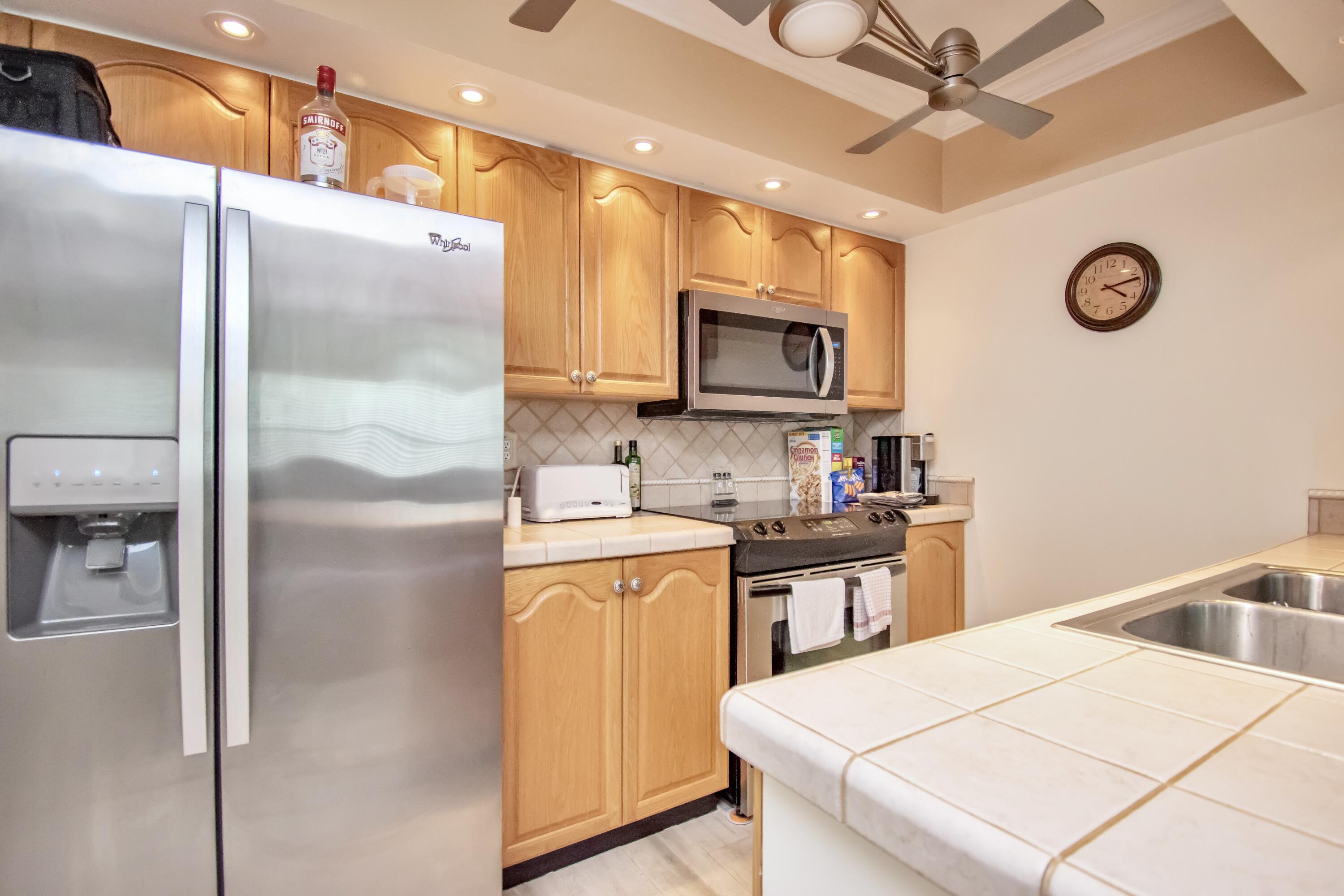 151 Waterside Drive Hypoluxo, FL 33462 - Photo 8 of 30 a kitchen with a refrigerator and a microwave