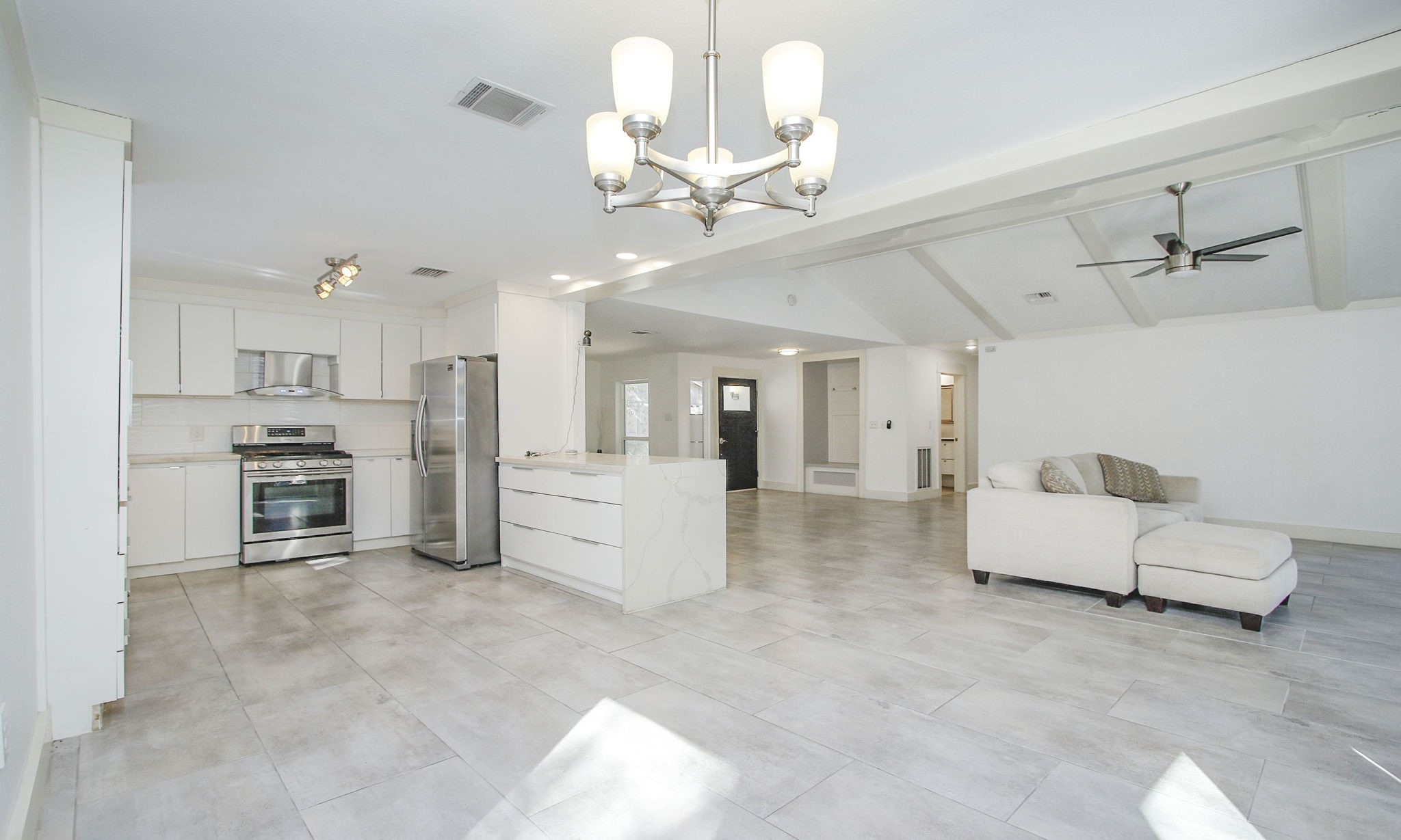 10611 Deerwood Road Houston, TX 77042 - Photo 20 of 47 a large white kitchen with a refrigerator a stove and a chandelier