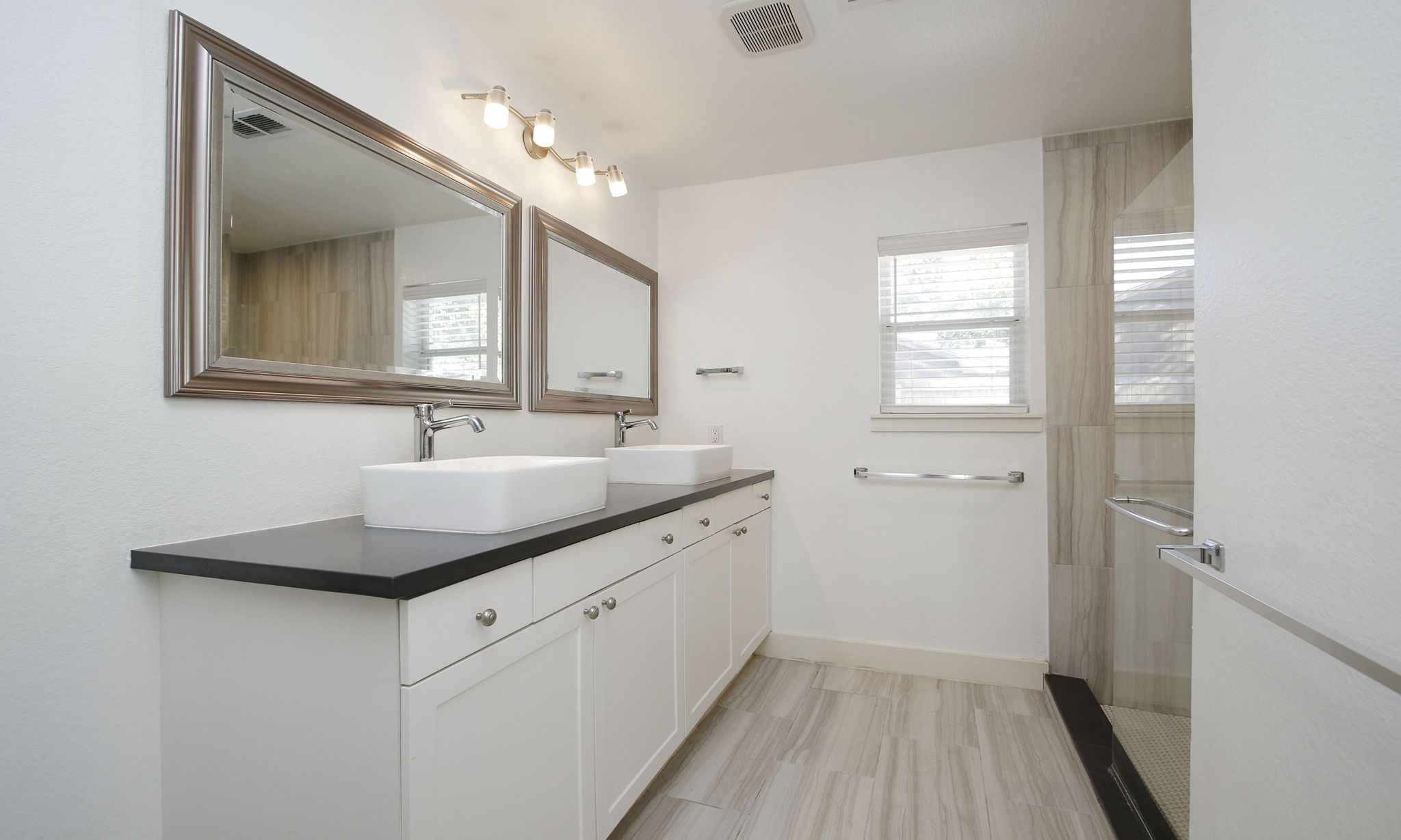 10611 Deerwood Road Houston, TX 77042 - Photo 23 of 47 a bathroom with a granite countertop sink a mirror and a vanity