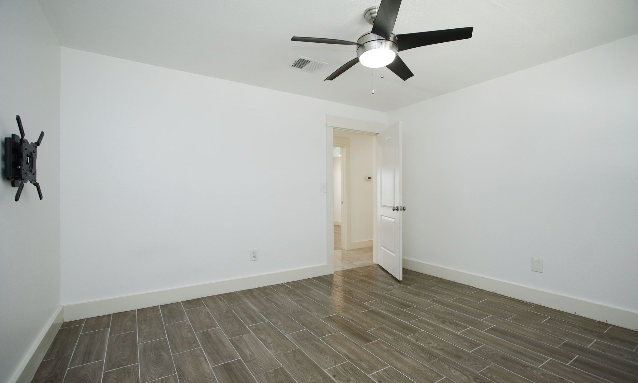 10611 Deerwood Road Houston, TX 77042 - Photo 30 of 47 an empty room with wooden floor and ceiling fan