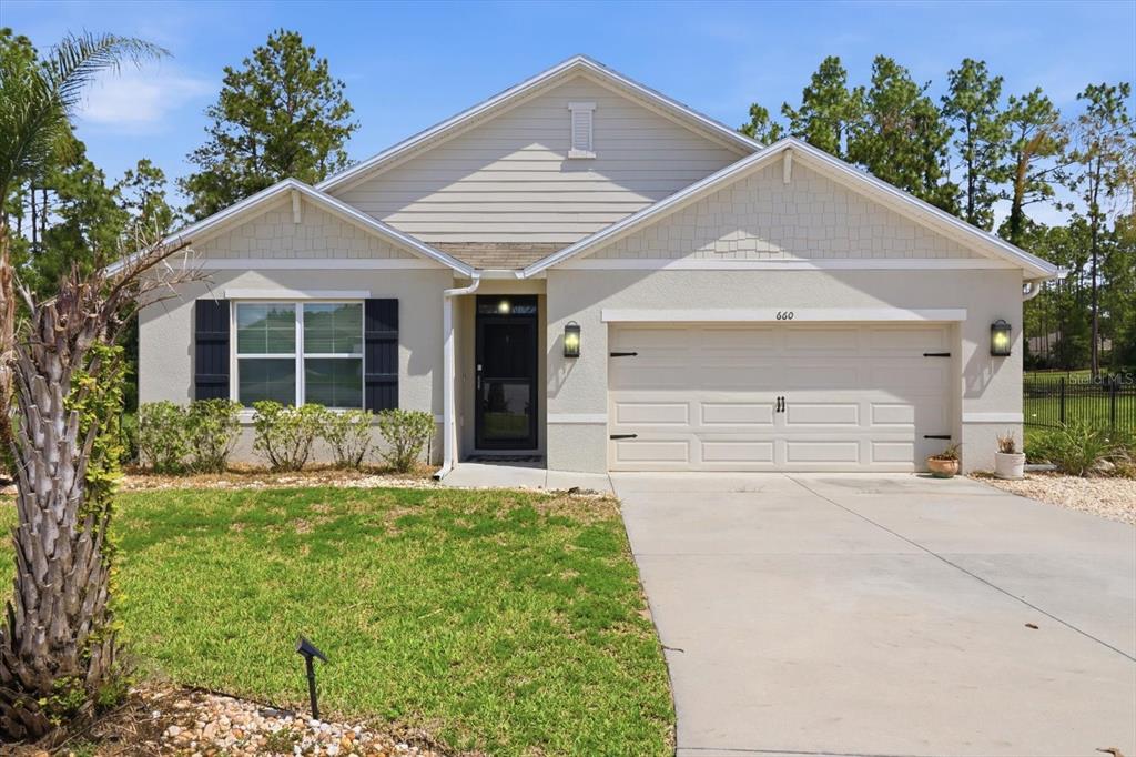 660 Hickory Course Loop Ocala, FL 34472 - Photo 1 of 45 a front view of a house with a yard and garage