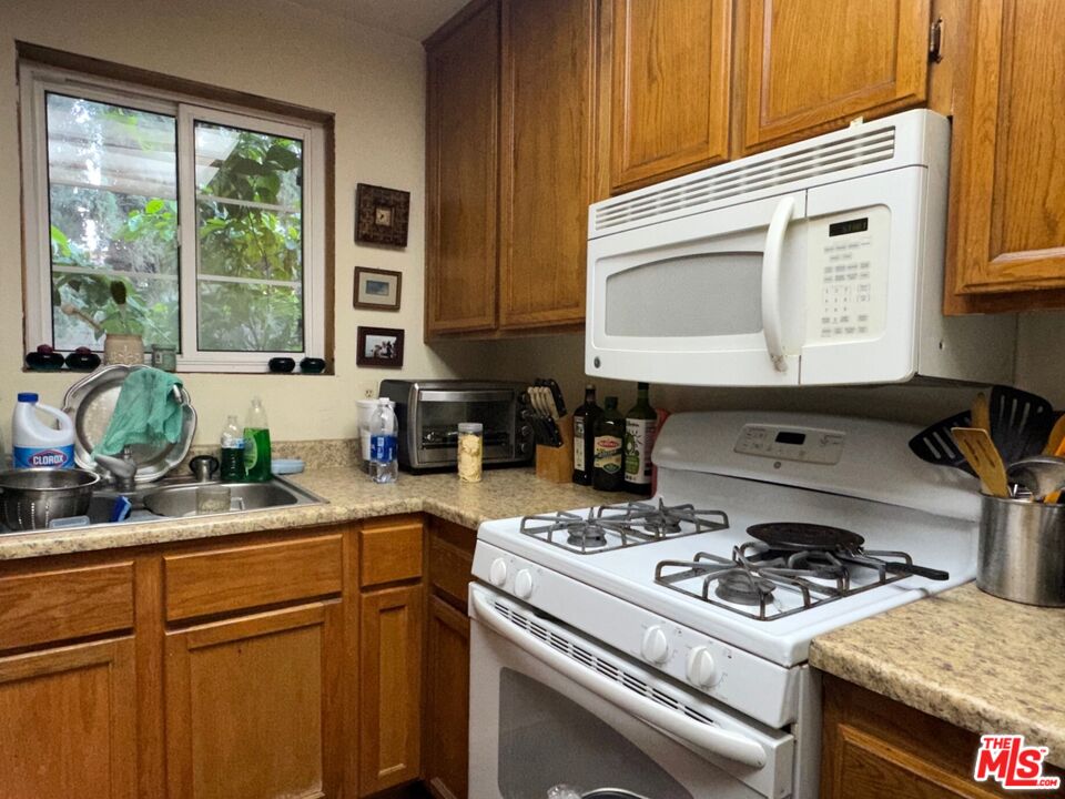 19928 Chase Street, Unit 27 Winnetka, CA 91306 - Photo 6 of 18 a kitchen with a stove and a white cabinets