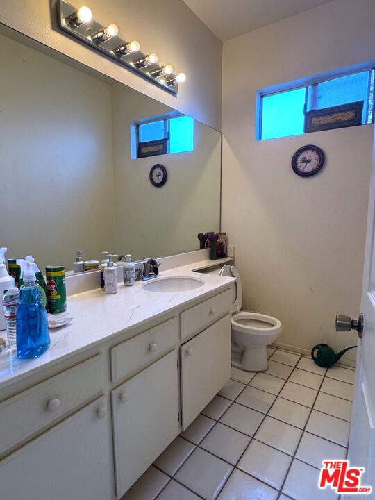 19928 Chase Street, Unit 27 Winnetka, CA 91306 - Photo 7 of 18 a bathroom with a sink mirror vanity and toilet