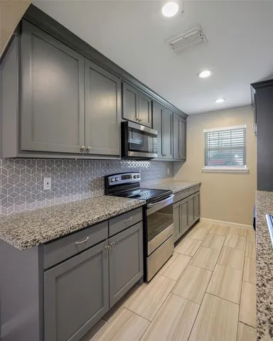 a kitchen with stainless steel appliances granite countertop a sink stove and cabinets