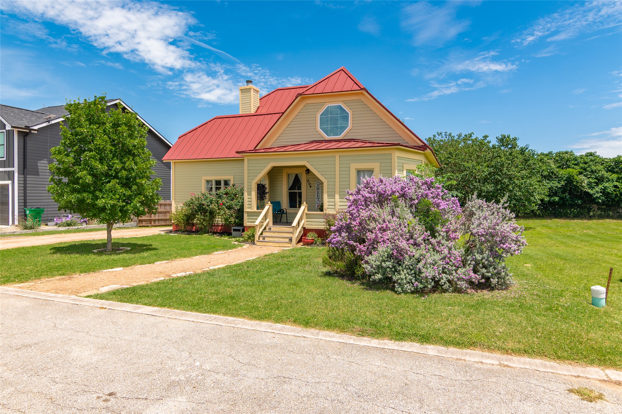 An eye-catching red metal roof and classic lap siding define this charming residential exterior.