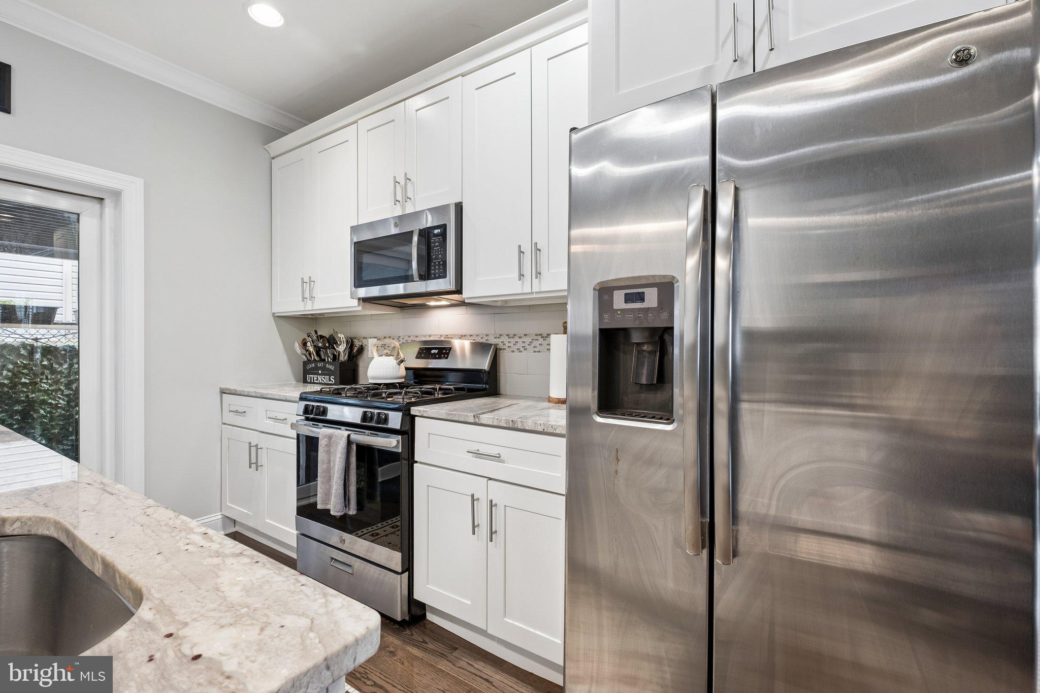 3356 Agate Street Philadelphia, PA 19134 - Photo 8 of 31 a kitchen with a refrigerator stove and white cabinets
