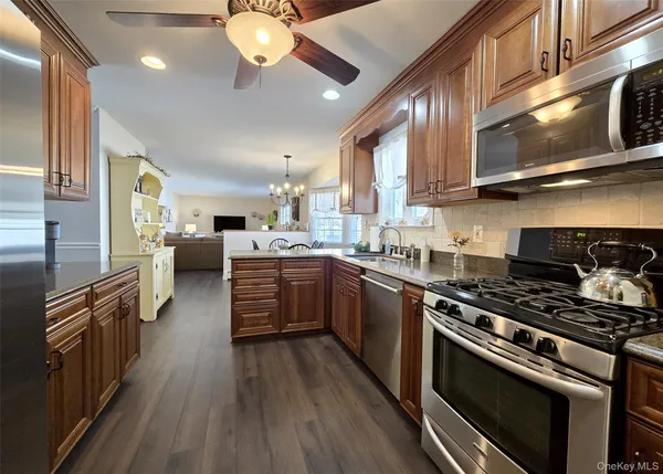 a kitchen with stainless steel appliances granite countertop a stove cabinets and wooden floor