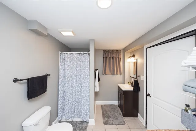 a bathroom with a toilet a sink and mirror