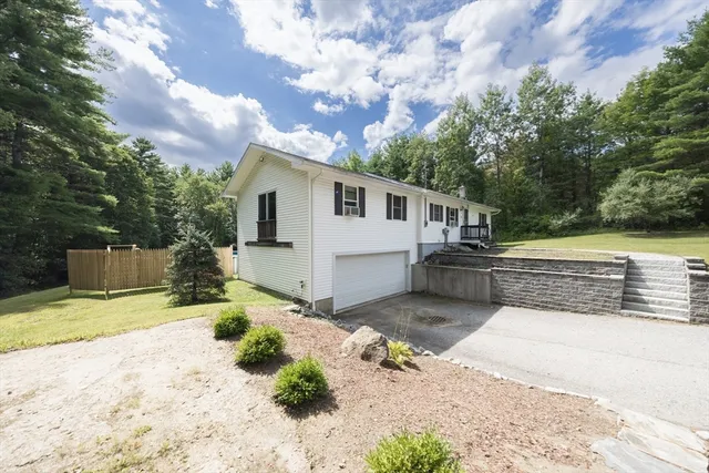 a front view of a house with a yard and trees