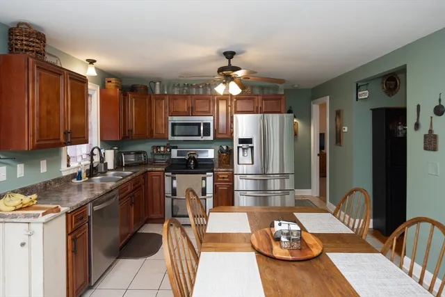 a kitchen with granite countertop stainless steel appliances a sink stove and refrigerator