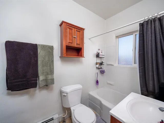 a white toilet sitting next to a bathroom sink and tub