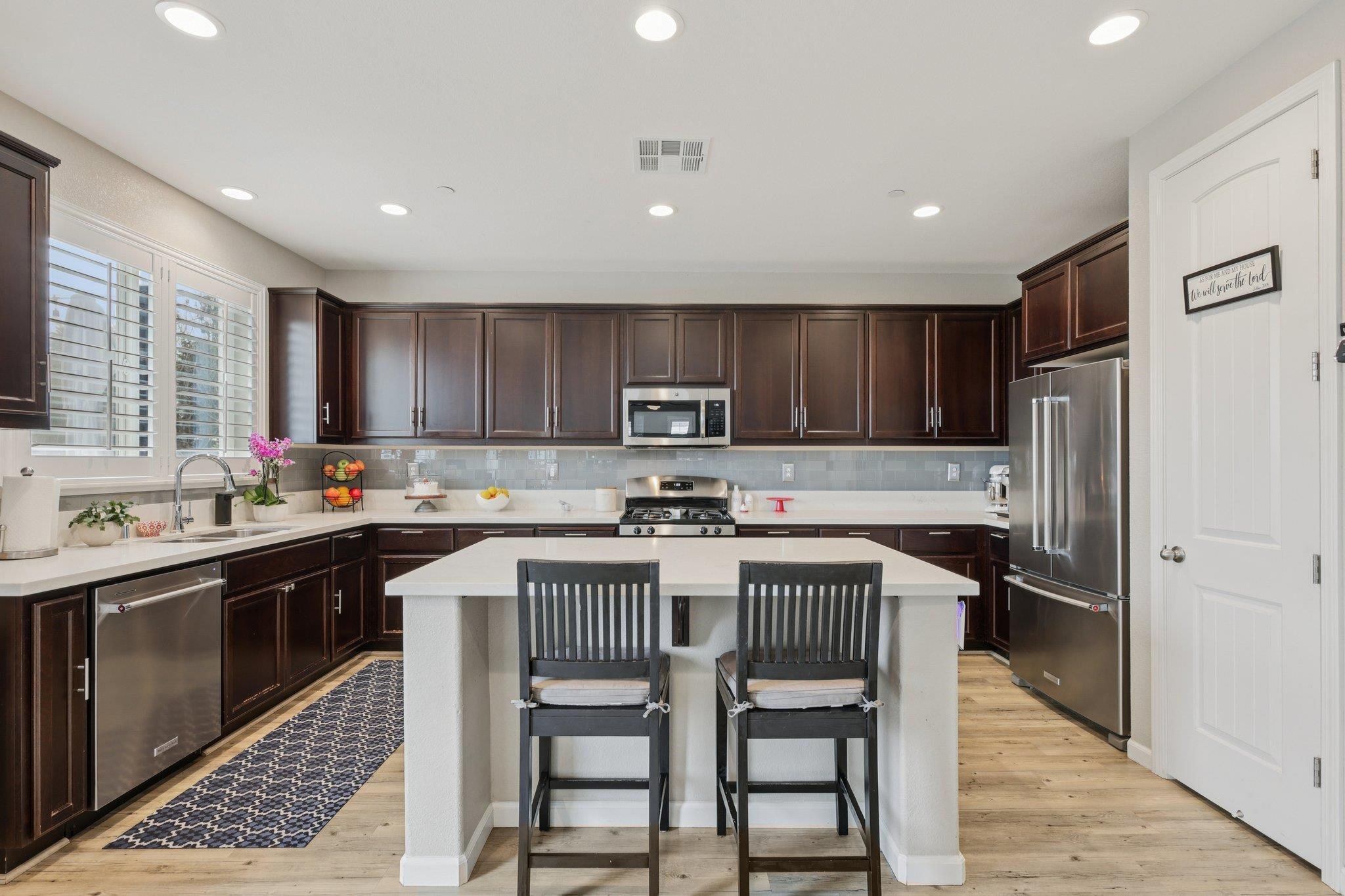 165 Little Ranch Circle Oakley, CA 94561 - Photo 14 of 60 Kitchen with a kitchen bar, dark brown cabinetry, stainless steel appliances, recessed lighting, and light wood finished floors