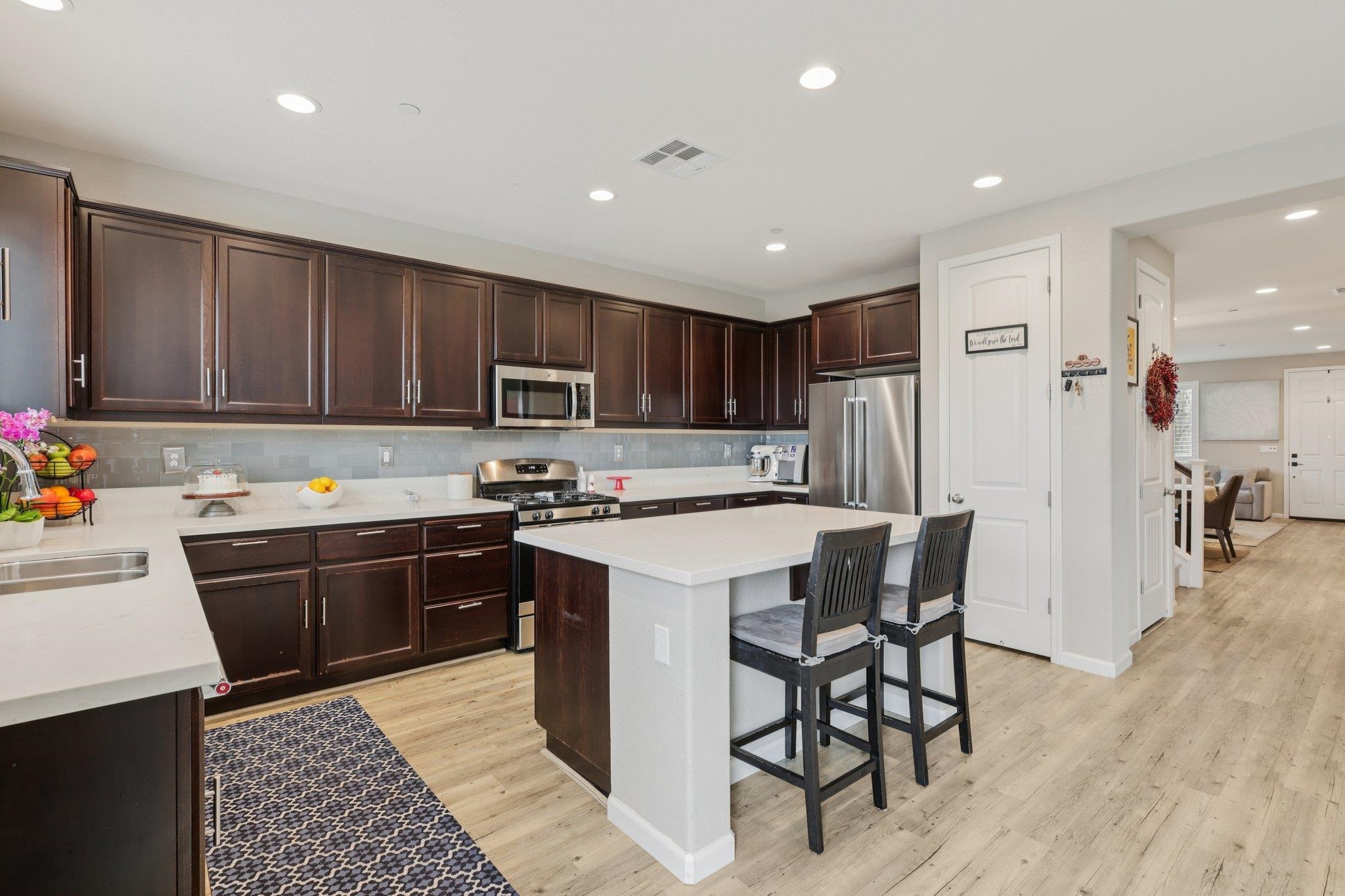 165 Little Ranch Circle Oakley, CA 94561 - Photo 15 of 60 Kitchen with dark brown cabinetry, a breakfast bar, stainless steel appliances, a center island, and recessed lighting