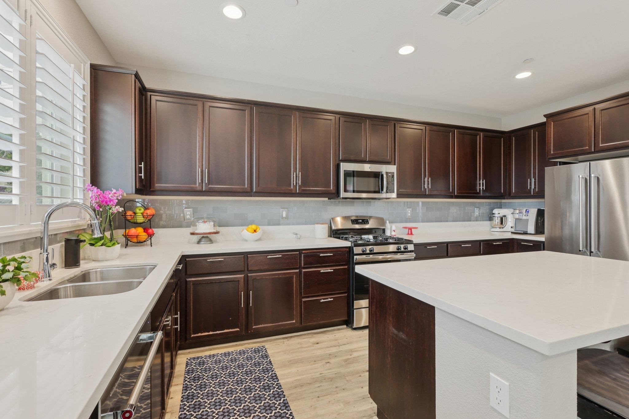 165 Little Ranch Circle Oakley, CA 94561 - Photo 16 of 60 Kitchen featuring dark brown cabinets, stainless steel appliances, light wood-style floors, a center island, and recessed lighting