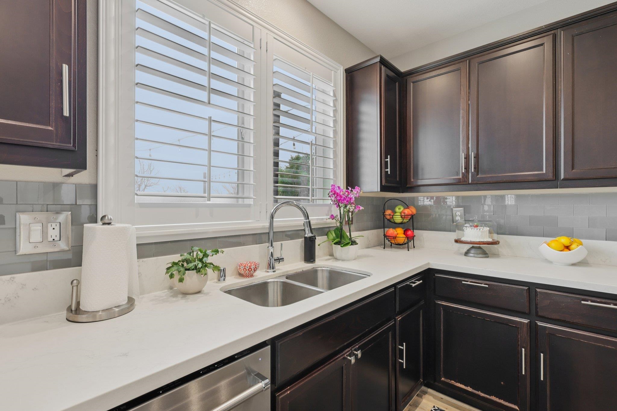 165 Little Ranch Circle Oakley, CA 94561 - Photo 17 of 60 Kitchen with dark brown cabinets, tasteful backsplash, light stone countertops, and dishwasher