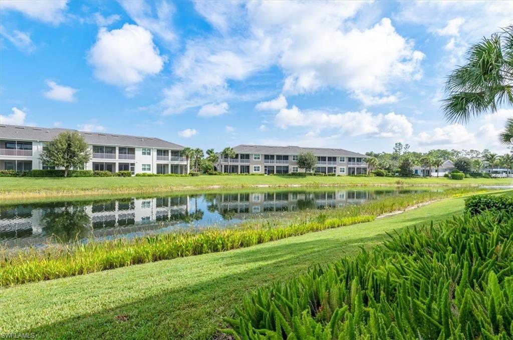 6954 Avalon Circle, Unit 703 Naples, FL 34112 - Photo 15 of 17 a view of a city with lawn chairs and a large tree
