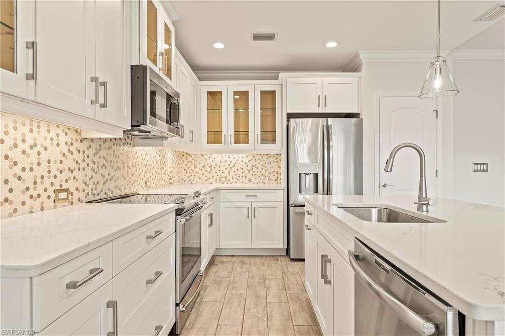 6954 Avalon Circle, Unit 703 Naples, FL 34112 - Photo 4 of 17 a kitchen with a sink stove and refrigerator