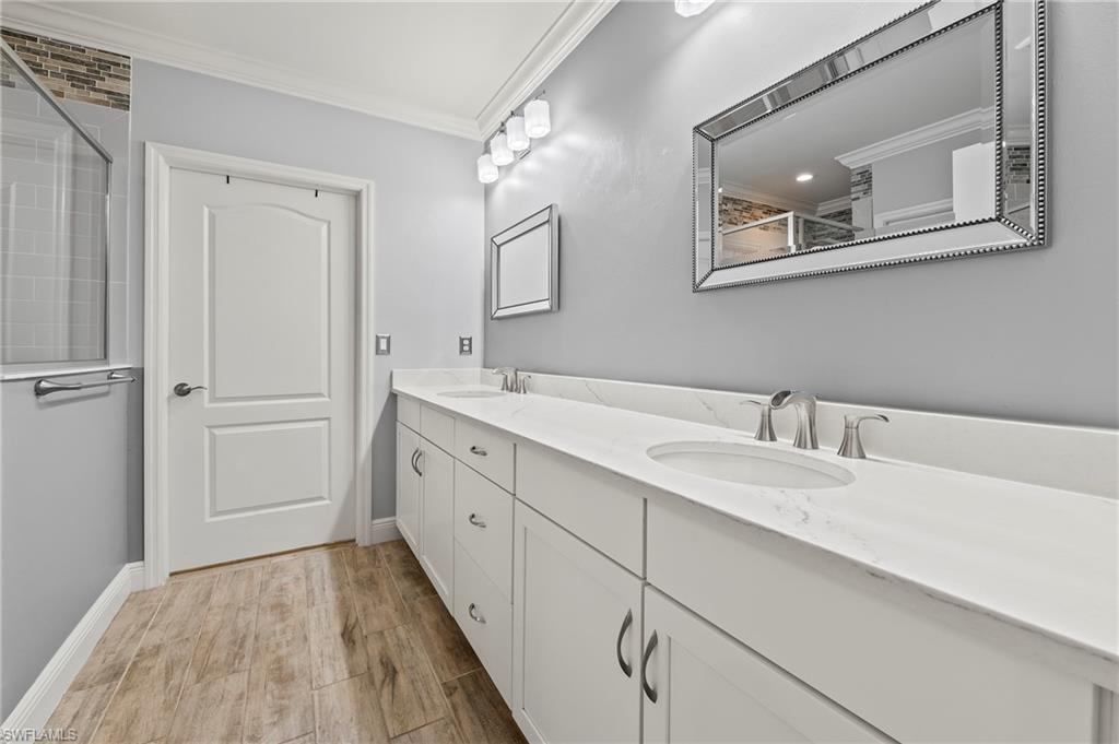 6954 Avalon Circle, Unit 703 Naples, FL 34112 - Photo 6 of 17 a spacious bathroom with a double vanity sink and a mirror